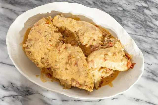 chicken paprikash with sour cream and paprika in a serving dish.