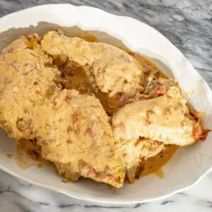 Chicken paprikash in a large serving bowl with sour cream sauce.