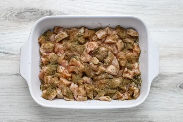 Chicken pot pie casserole prep: Diced chicken in the baking dish.