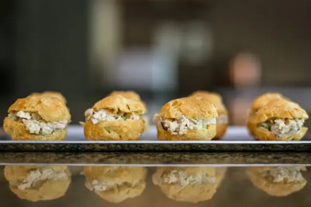 chicken salad puffs lined up on an appetizer tray