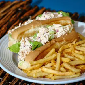 chicken salad sandwiches on a plate with fries on the side