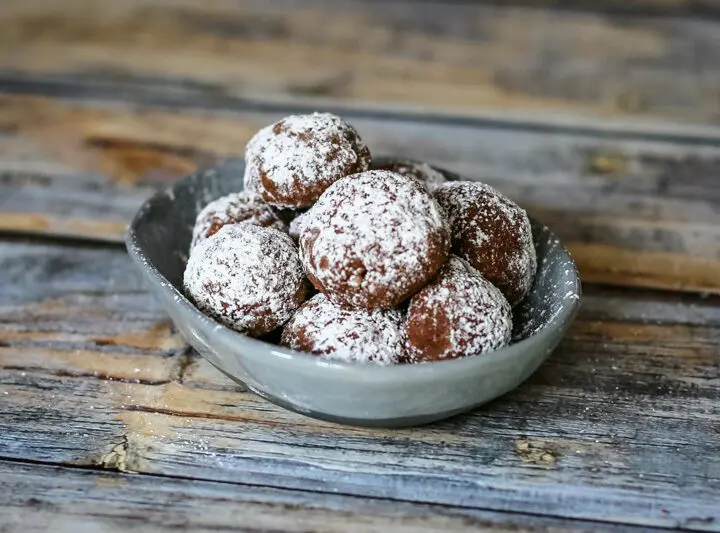 Chocolate butterball cookies in a small dish.