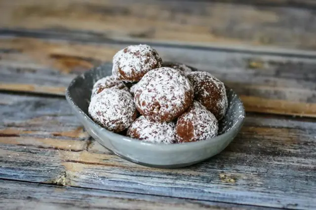 Chocolate butterball cookies in a small dish.