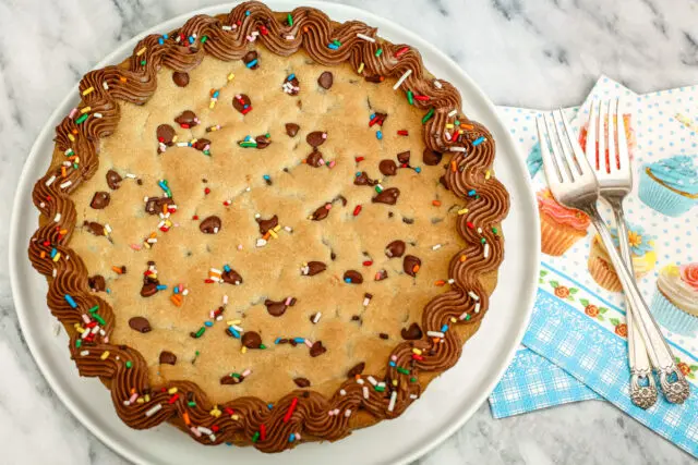 Overhead shot of our chocolate chip cookie cake decorated with chocolate frosting and sprinkles.