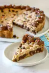 A chocolate chip cookie cake decorated with chocolate frosting and sprinkles.