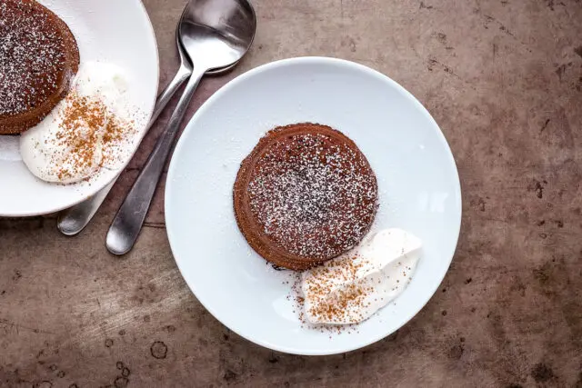 Overhead photo of a chocolate molten lava cake, aka chocolate fondant, with whipped cream.