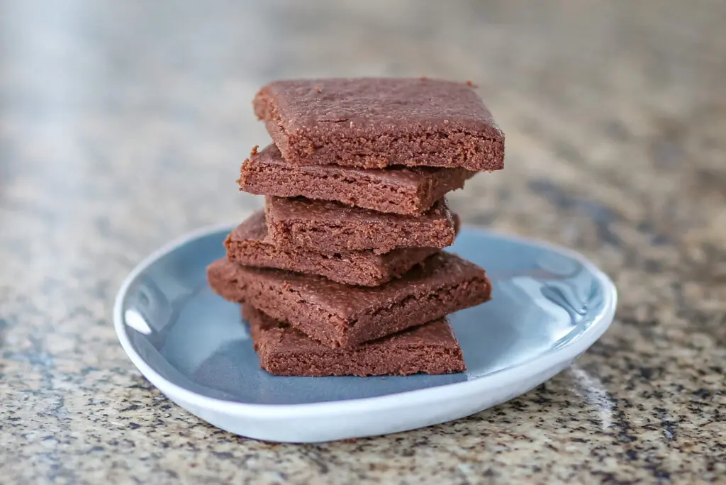 chocolate shortbread cookies stacked on a small plate