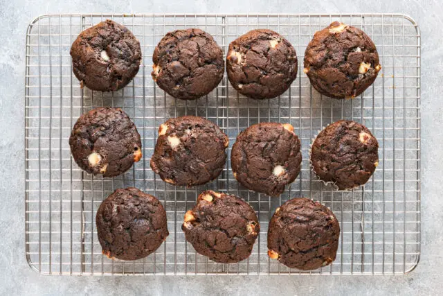 Baked chocolate zucchini cupcakes on a cooling rack.