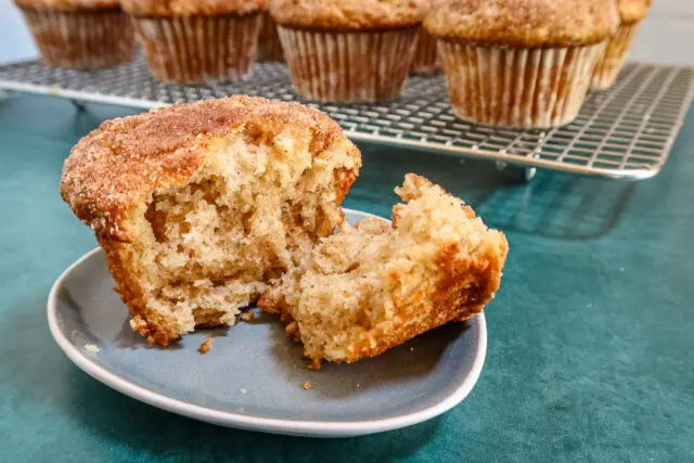 A cinnamon muffin split to show the fluffy center.