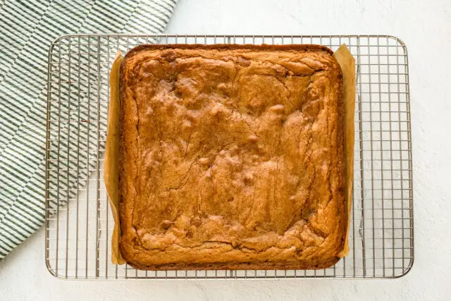 Baked cinnamon roll brownies cooling on the rack.