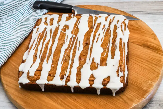 Baked cinnamon roll brownies on a cutting board.