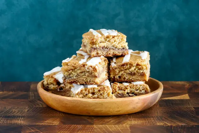 A stack of cinnamon roll blondies, cut to show the lovely cinnamon swirls.