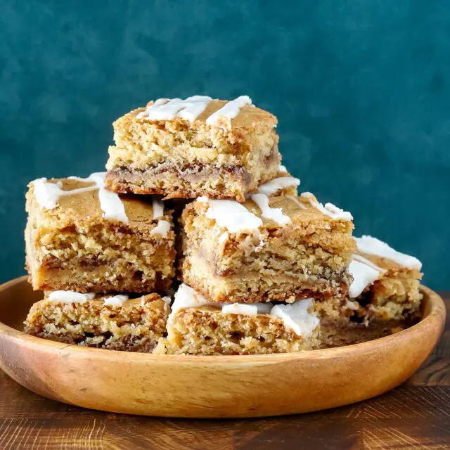 A stack of cinnamon roll blondies, cut to show the lovely cinnamon swirls.