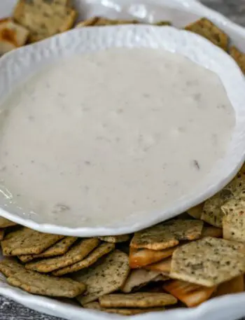 clam dip in a serving bowl with crackers