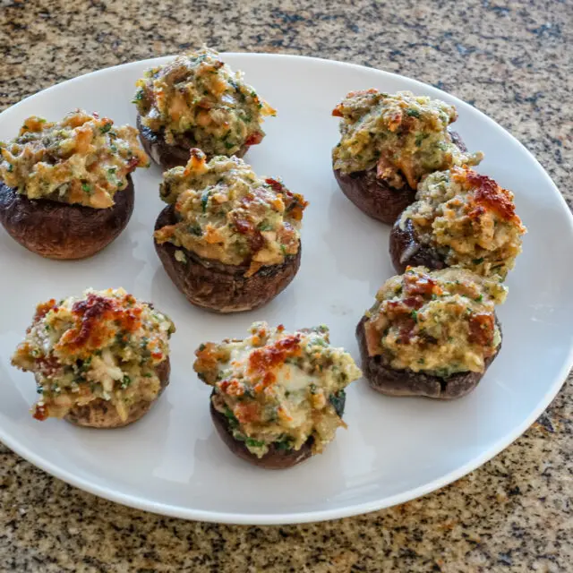 Easy stuffed mushrooms with clams in the bread stuffing mix, along with bacon, Parmesan cheese, and minced vegetables.