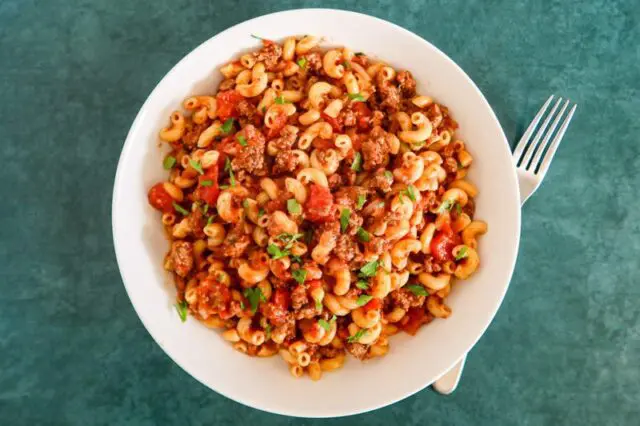 american chop suey in a bowl with parsley garnish