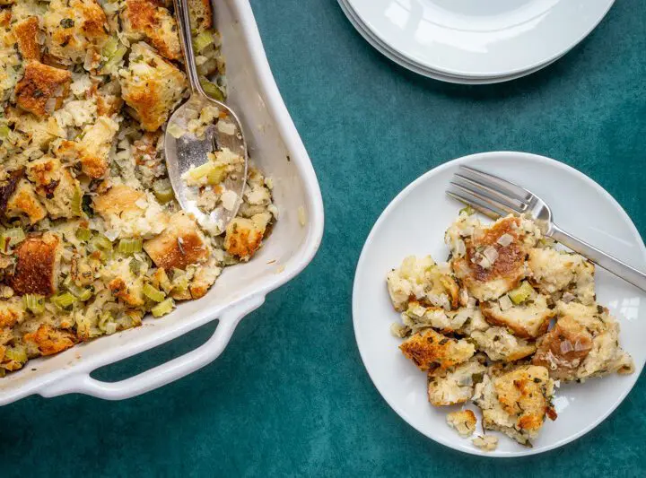 bread stuffing or dressing on a plate with baking dish on the side