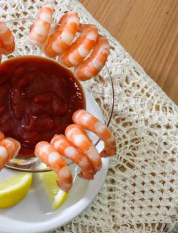 overhead shot of cocktail sauce surrounded by shrimp