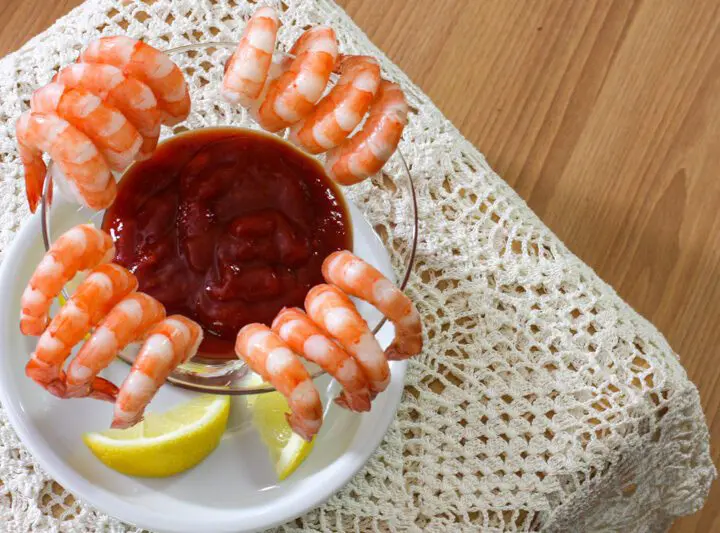 overhead shot of cocktail sauce surrounded by shrimp