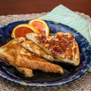 A serving of sliced French toast with orange slices on the side.