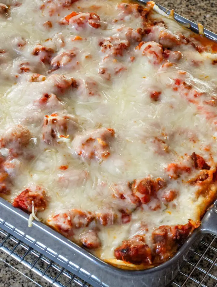 Homemade easy lasagna in a baking dish on a cooling rack.