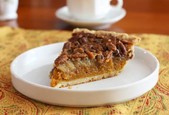 A classic pumpkin pecan pie on a dessert plate