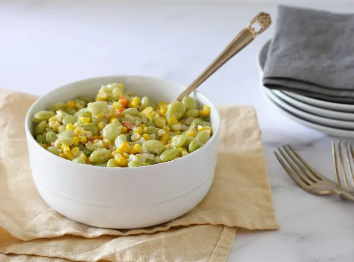 a serving bowl of succotash with corn and lima beans