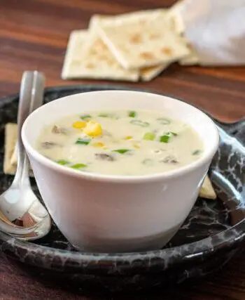 corn and bacon chowder on a luncheon plate with crackers