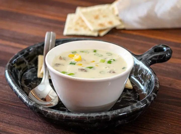 corn and bacon chowder on a luncheon plate with crackers