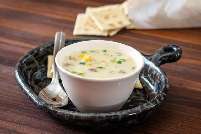 corn and bacon chowder on a luncheon plate with crackers