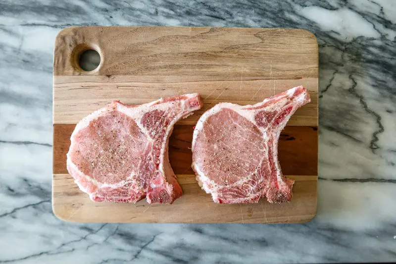 pork chops seasoned on a cutting board