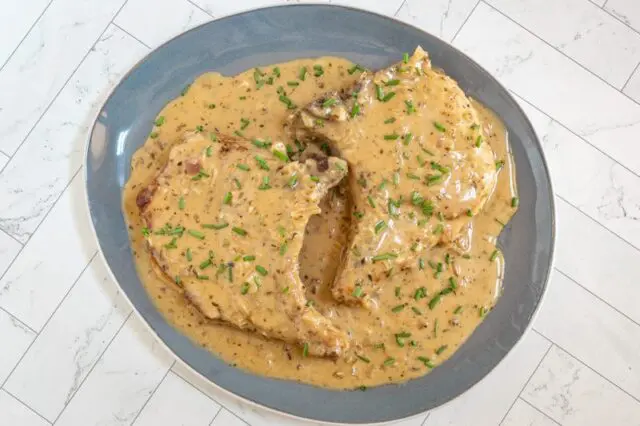 creamy apple cider pork chops with chive garnish