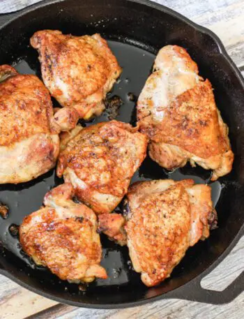 crispy skin chicken thighs in an iron skillet