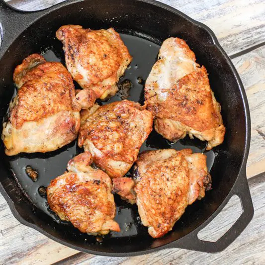 crispy skin chicken thighs in an iron skillet