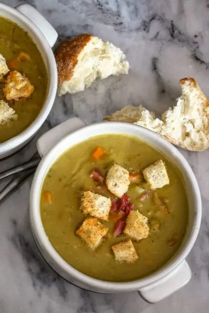 bowls of split pea soup and croutons