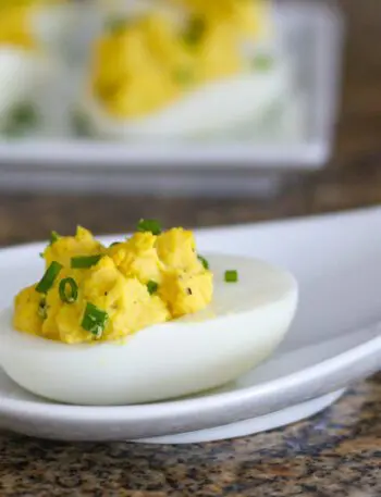 curried deviled eggs with chopped chives for garnish