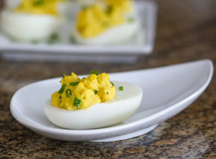 curried deviled eggs with chopped chives for garnish