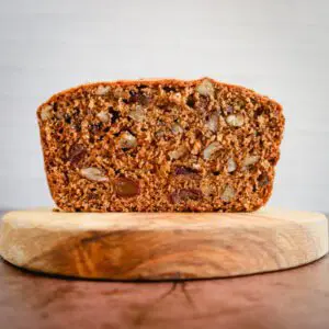 Sliced loaf of date nut bread on a cutting board