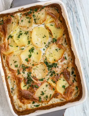 Baked dauphinoise potatoes with parsley garnish - potato gratin.