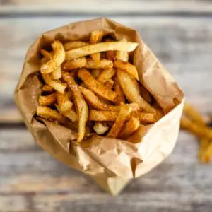 deep fried french fries in a brown paper bag