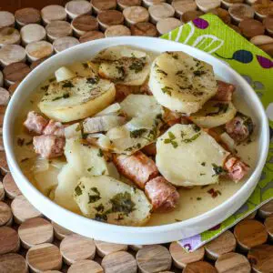 A plate of dublin coddle, potatoes and sausages