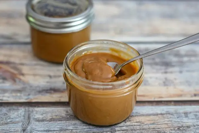 jars of slow cooker dulce de leche caramel with spoon