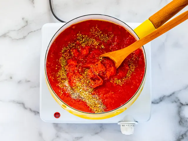 Combining pizza sauce ingredients.