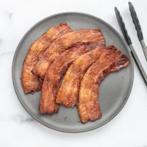 A plate with crisp baked bacon.