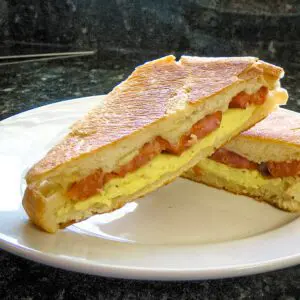 egg and sausage panini with spicy andouille sausage, on a plate