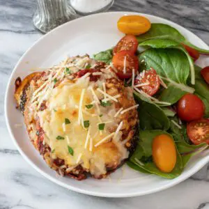 a plate with eggplant parmesan and a small salad on the side