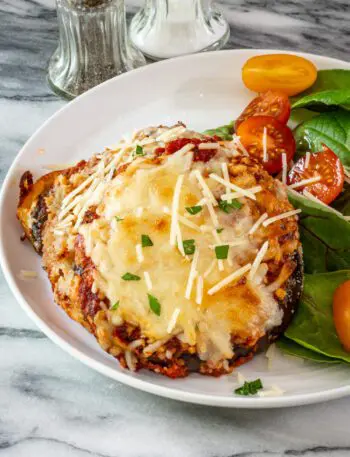 eggplant parmesan serving on a plate with salad