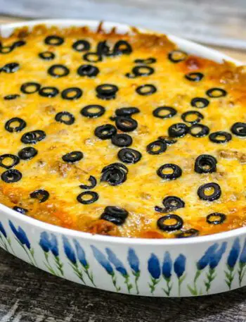 an enchilada casserole covered with cheese and sliced olives.