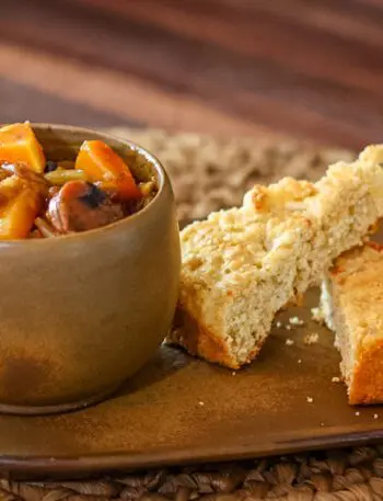 baked beans with butternut squash and smoked sausage on a plate with cornbread