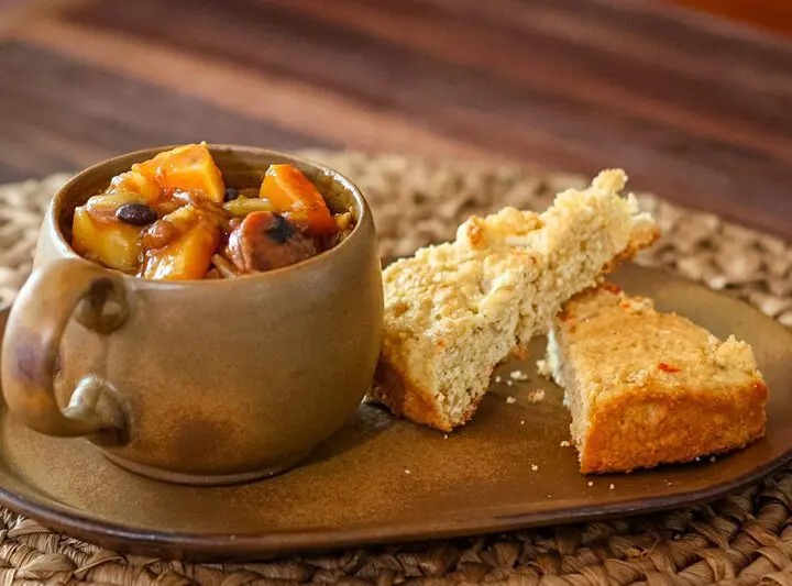 baked beans with butternut squash and smoked sausage on a plate with cornbread